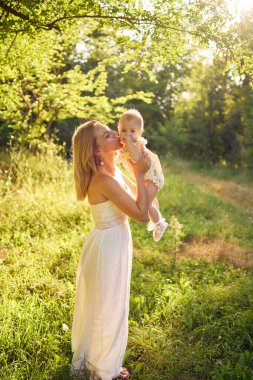  Anne, kızıyla güneşli bir bahçede oynuyor.