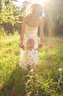  Anne, kızıyla güneşli bir bahçede oynuyor.
