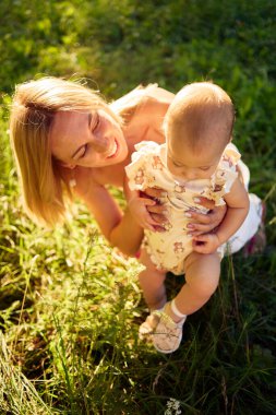  Anne, kızıyla güneşli bir bahçede oynuyor.