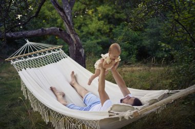 Baba hamakta küçük kızıyla oynuyor.