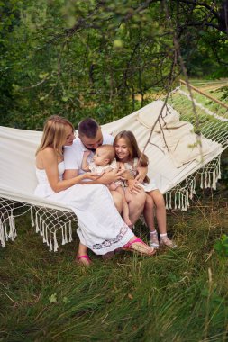 Aile annesi, baba kız kardeş genç ve bebek hamakta