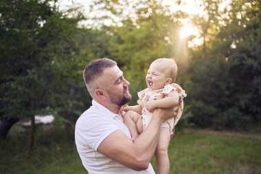          Baba küçük kızıyla bahçede oynuyor.                      
