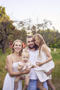 Parkta yürüyüşe çıkmış dört kişilik bir aile.