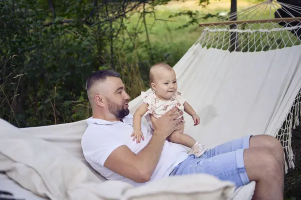 stock image dad playing with his baby daughter in  hammock