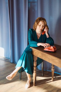 Retro telefonlu orta yaşlı bir kadın.