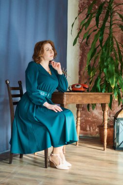 Retro telefonlu orta yaşlı bir kadın.