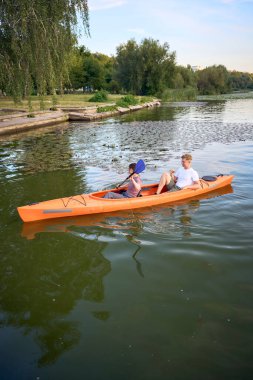     Birbirlerine aşık çiftler gün batımında nehirde kano yapıyorlar.                           