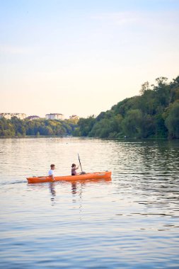     Birbirlerine aşık çiftler gün batımında nehirde kano yapıyorlar.                           