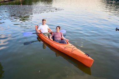     Birbirlerine aşık çiftler gün batımında nehirde kano yapıyorlar.                           