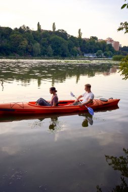     Birbirlerine aşık çiftler gün batımında nehirde kano yapıyorlar.                           