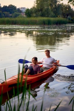     Birbirlerine aşık çiftler gün batımında nehirde kano yapıyorlar.                           