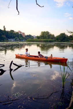     Birbirlerine aşık çiftler gün batımında nehirde kano yapıyorlar.                           