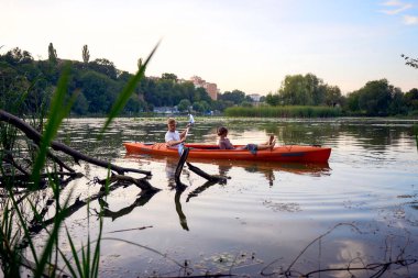     Birbirlerine aşık çiftler gün batımında nehirde kano yapıyorlar.                           
