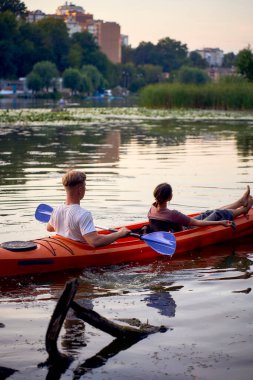     Birbirlerine aşık çiftler gün batımında nehirde kano yapıyorlar.                           