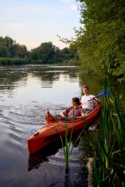     Birbirlerine aşık çiftler gün batımında nehirde kano yapıyorlar.                           