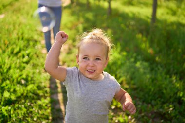 Genç bir kız kardeş bebek için sabun köpüğü üflüyor.                               