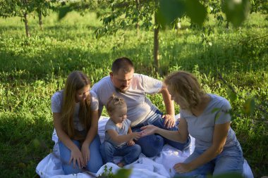  Dört kişilik aile parkta piknik yapıyor.                    