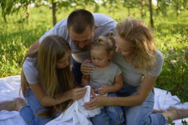  Dört kişilik aile parkta piknik yapıyor.                    