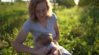 Bir anne yeni yürümeye başlayan bir çocuğu giydirir. Bağırır, giyinmekten nefret eder.
