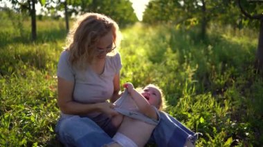 Bir anne yeni yürümeye başlayan bir çocuğu giydirir. Bağırır, giyinmekten nefret eder.