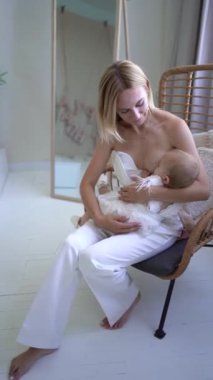 Bir anne bebeğini emziriyor, Minimalist stil iç mekan, pastel renkler