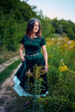 Yazın gün batımında sahada estetik tarzda giyinmiş bir kadın.