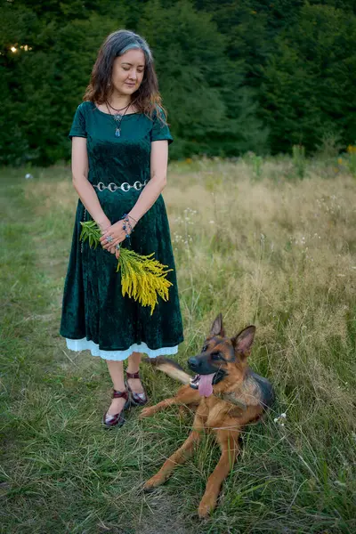 stock image  woman in a Whimsical Aesthetic style dress with a German shepherd in a field