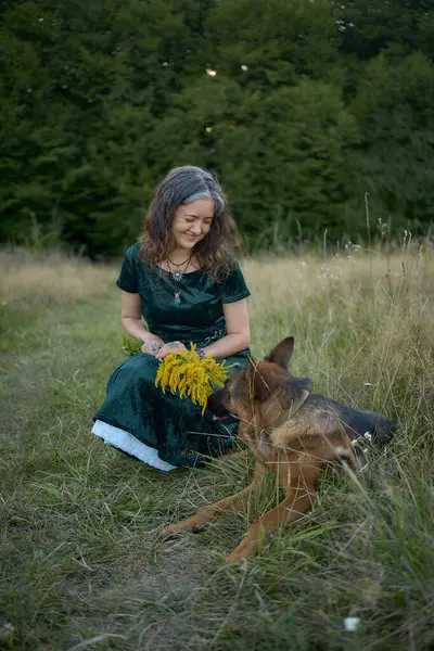 stock image  woman in a Whimsical Aesthetic style dress with a German shepherd in a field