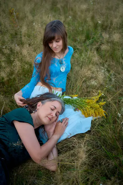 stock image two woman in a whimsical aesthetic style dress in a field in the summer at a sunset