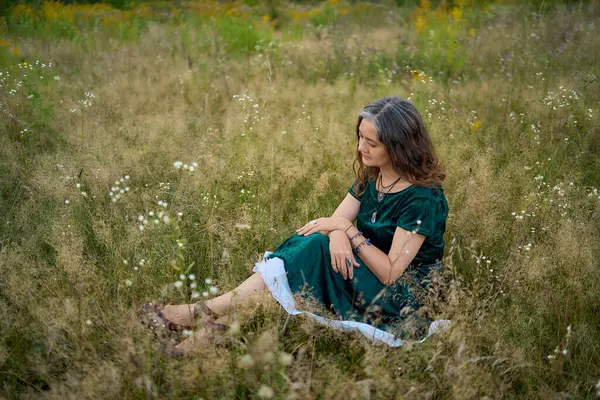 stock image         a woman in whimsical aesthetic style dress in field in summer at sunset                       