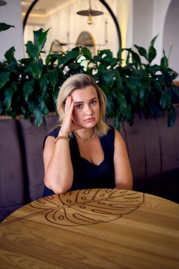  Orta yaşlı ve zengin bir kadın şık bir restoranda eski moda kıyafetler giyiyor.