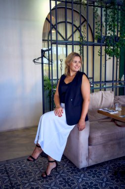        Orta yaşlı ve zengin bir kadın şık bir restoranda eski moda kıyafetler giyiyor.                         