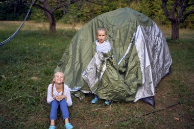               Anne ve küçük kızları ormanda bir çadır kuruyorlar, çocuklarla kamp yapıyorlar.                                                