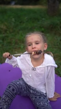 Anne ve kızları kamp ateşinde kızartıp marshmallow yiyorlar, çocuklarla kamp yapıyorlar.