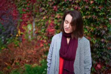       30 yaşında, orta boylu, sonbahar bahçesinde kırmızı çarşaf giymiş bir kadın.                        