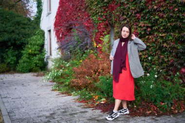       30 yaşında, orta boylu, sonbahar bahçesinde kırmızı çarşaf giymiş bir kadın.                        