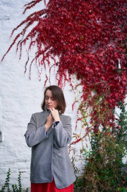       30 yaşında, orta boylu, sonbahar bahçesinde kırmızı çarşaf giymiş bir kadın.                        