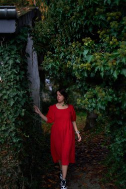       30 yaşında, orta boylu, sonbahar bahçesinde kırmızı çarşaf giymiş bir kadın.                        