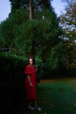       30 yaşında, orta boylu, sonbahar bahçesinde kırmızı çarşaf giymiş bir kadın.                        