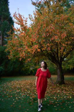       30 yaşında, orta boylu, sonbahar bahçesinde kırmızı çarşaf giymiş bir kadın.                        