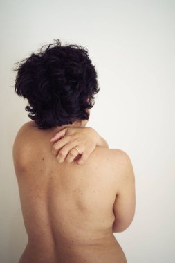 Arkadan külotlu ve kilolu genç bir kadın.                   