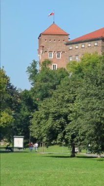 KRAKOW, POLAND - SEP 05, 2024: insanlar kraliyet şatosunun yanındaki parkta yürüyorlar