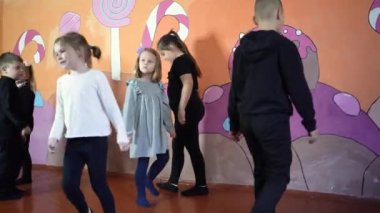 5-7 yaşlarındaki çocuklar oyunculuk sınıfında öğretmenleri ile ders dışı aktiviteler yapıyorlar.