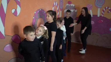 5-7 yaşlarındaki çocuklar oyunculuk sınıfında öğretmenleri ile ders dışı aktiviteler yapıyorlar.