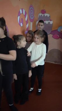 5-7 yaşlarındaki çocuklar oyunculuk sınıfında öğretmenleri ile ders dışı aktiviteler yapıyorlar.