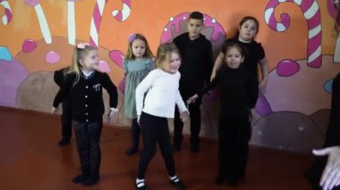 5-7 yaşlarındaki çocuklar oyunculuk sınıfında öğretmenleri ile ders dışı aktiviteler yapıyorlar.