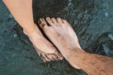 Sahilde kadın ve erkeğin çıplak ayakları.