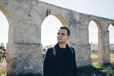 Antik Kamares Aqueduct yakınlarında genç bir adam, Larnaca, Kıbrıs