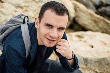 Kıbrıs Rum Kesimi 'nin kayalık Ayia Napa kıyısında sırt çantalı bir gencin portresi