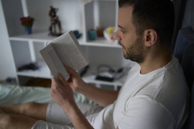   30 yaşında bir adam İncil okur ve yatakta dua eder, sabah rutini.                             